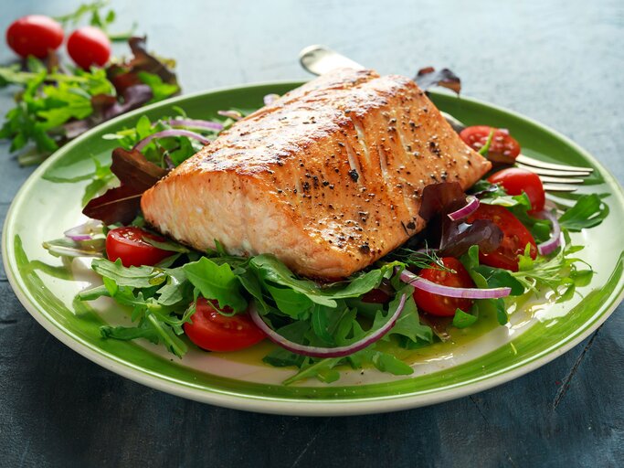 Gebackenes Lachssteak mit Tomate, Zwiebel, Mischung aus grünen Blätter Salat | © iStock.com | DronG