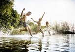 Freunde, die zusammen im Wasser im See plantschen. | © iStock.com / TommL