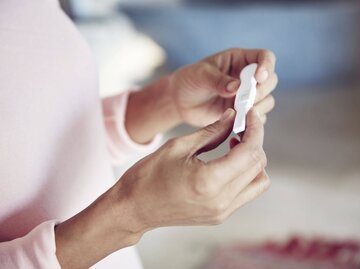 Eine Frau hält einen Schwangerschaftstest in der Hand. | © iStock.com / laflor