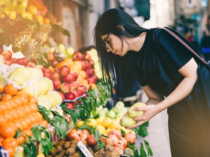 Frau kauft Obst in einem Geschäft | © iStock.com / byakkaya
