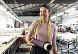 Lächelnde junge Frau in einer Mode-Fabrik | © iStock.com / Elitsa Deykova