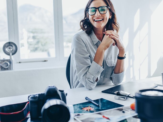 Fotoredakteurin sitzt am Schreibtisch | © iStock.com / jacoblund