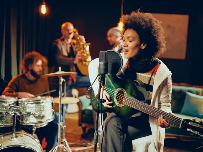 Hübsche Musikerin an der Gitarre | © iStock.com / millann