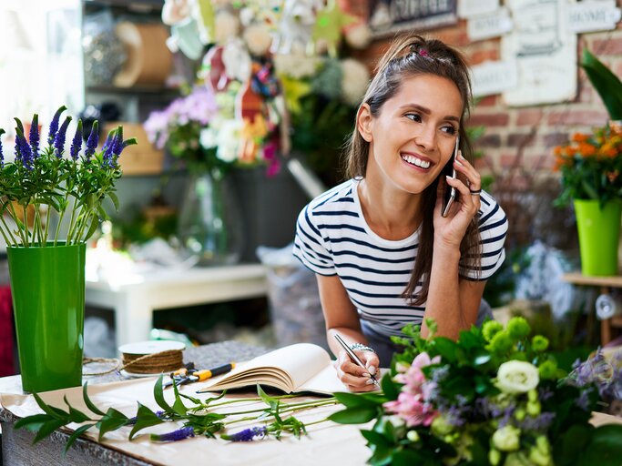 hübsche Floristin telefoniert | © iStock.com / BartekSzewczyk