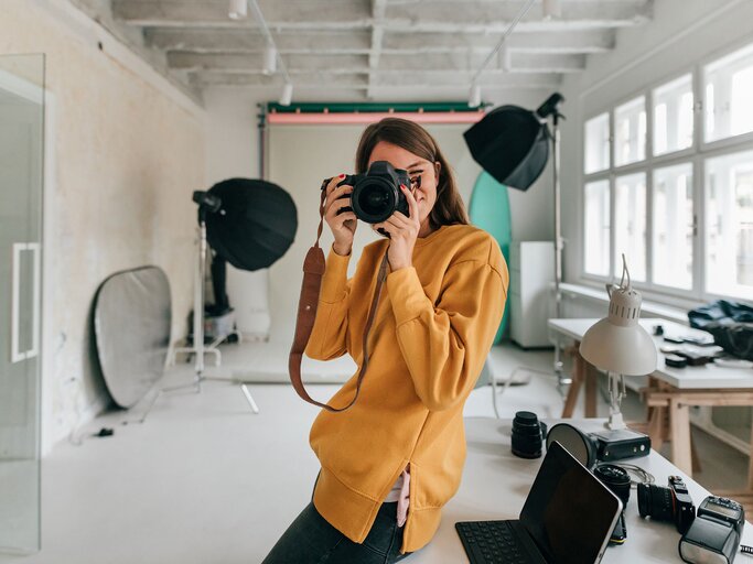 Fotografin arbeitet in einem Studio | © iStock.com / AleksandarNakic