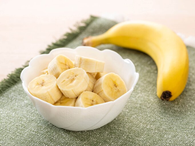 In einer Schüssel befindet sich eine aufgeschnittene Banane.  | © iStock.com / kuppa_rock