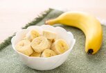 In einer Schüssel befindet sich eine aufgeschnittene Banane.  | © iStock.com / kuppa_rock