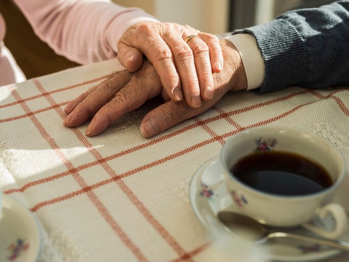 Hände eines Seniorenehepaares beim Kaffetrinken | © Getty Images | Westend61