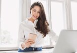 Schöne Geschäftsfrau mit Laptop und Smartphone  | © iStock.com / Poike