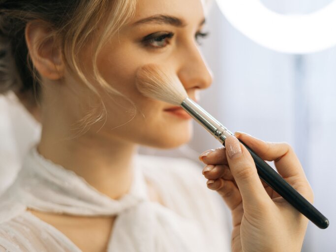 Frau wird mit Pinsel geschminkt | © iStock.com / dikushin