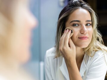 Frau trägt Make-Up auf | © iStock.com / skynesher