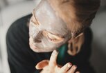 Frau trägt sich eine Heilerde-Maske im Gesicht auf | © iStock.com / Aja Koska