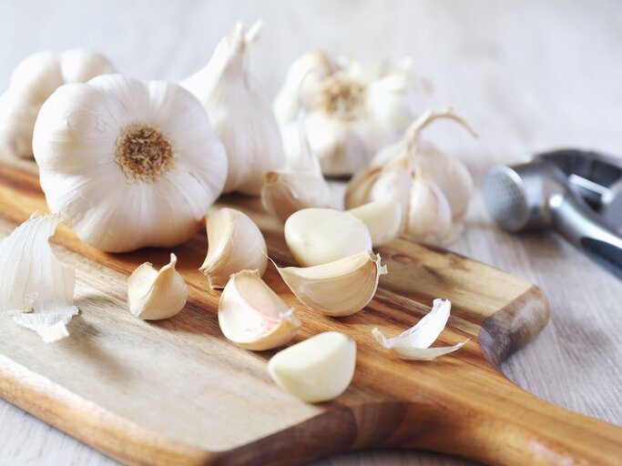 Knoblauch auf Schneidebrett | © iStock.com / photosimysia