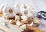 Knoblauch auf Schneidebrett | © iStock.com / photosimysia