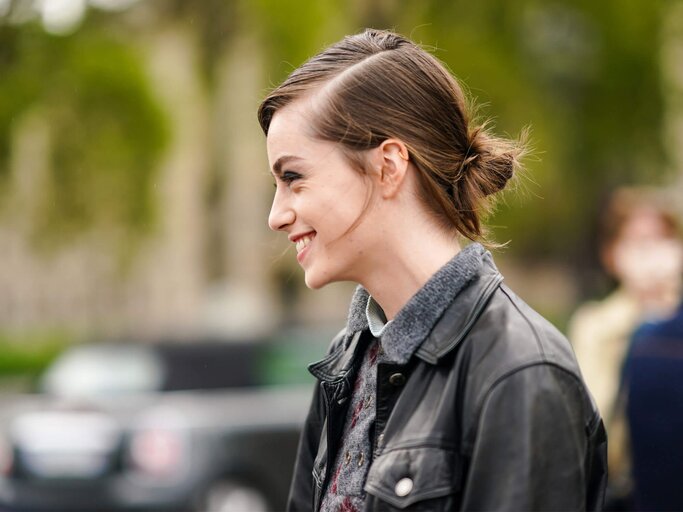 Model auf der Fashion Week trägt eine Frisur mit Seitenscheitel und tiefen Dutt im Undone-Stil. | © gettyimages.de / Edward Berthelot