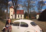 Enie van de Meiklokjes steht neben ihrem weißen Käfer-Oldtimer-Auto  | © Instagram | @enieimturm