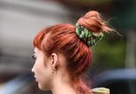 Frau mit roten Haaren und hohem Dutt von hinten  | ©  gettyimages.de | Daniel Zuchnik