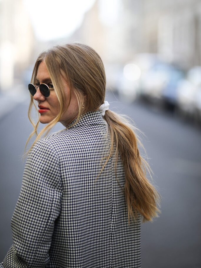 Portrait von einer Frau mit tiefem Pferdeschwanz und Sonnenbrille | ©  gettyimages.de| Jeremy Moeller