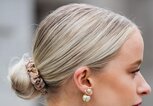 Frau mit Haarknoten und Perlohrringen von der Seite | ©  gettyimages.de | Christian Vierig