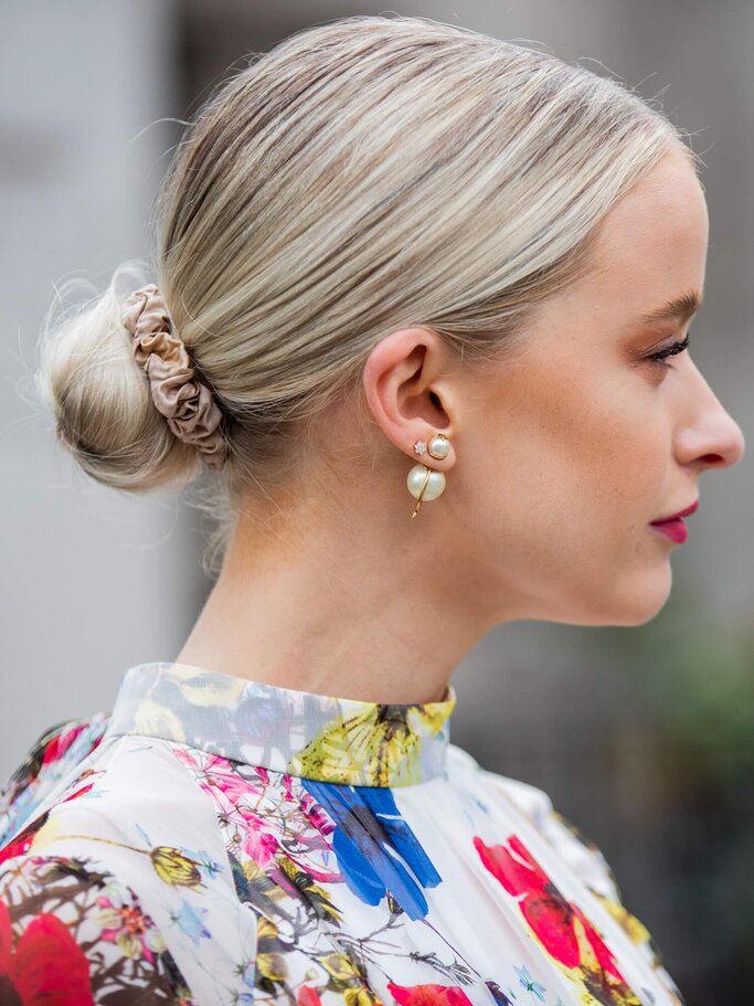 Frau mit Haarknoten und Perlohrringen von der Seite | ©  gettyimages.de | Christian Vierig