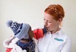 Enie van de Meiklokjes in Kenia mit einem Kind auf dem Arm | © Instagram | @enieimturm