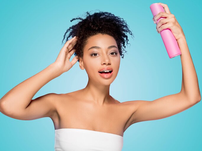 Junge Frau mit Trockenshampoo in der Hand | © gettyimages.de | LightFieldStudios 