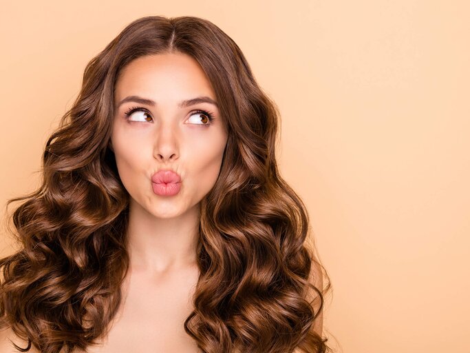 Frau mit Locken und Kussmund  | © gettyimages.de | Deagreez