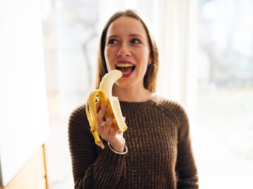 Frau isst eine Banane | © Getty Images/ProfessionalStudioImages