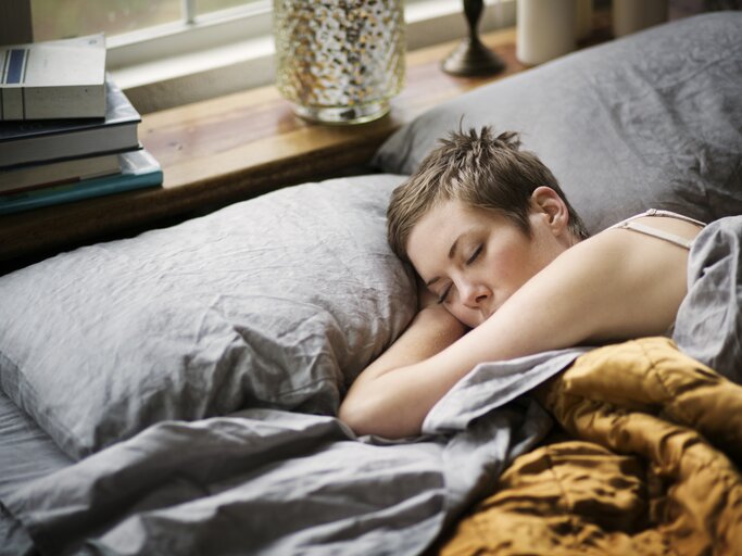 Frau lieg müde im Bett und kann nicht schlafen | © GettyImages/	Cavan Images