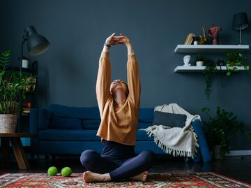 Frau macht in ihrem Wohnzimmer Sport | © GettyImages/Nadin Tambasova