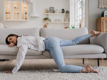 Frau liegt müde auf der Couch und macht Mittagsschlaf | © GettyImages/	Iona Studio