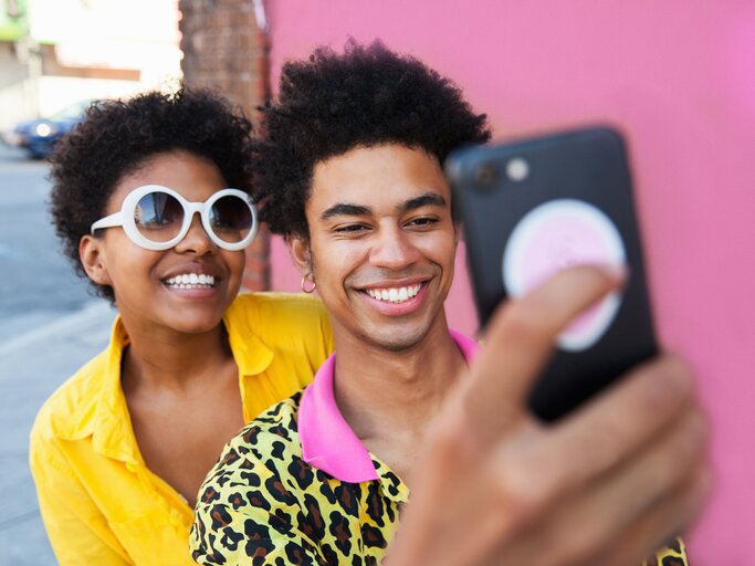 Junge Pärchen macht ein lachendes Selfie | © Getty Images/	Stephen Zeigler