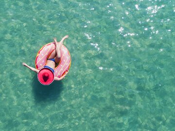 Frau auf einem Schwimmreifen im Meer | © Getty Images/	Peter Cade