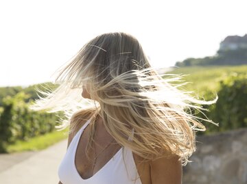 Frau mit blonden Haaren im Sommer | © GettyImages/Margarita Almpanezou