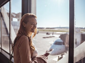 Frau wartet am sonnigen Flughafen | © GettyImages/	Marko Geber
