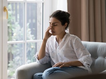 Frau hat Kopfschmerzen | © Shutterstock.com/fizkes