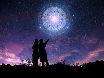 Paar blickt in den Himmel, wo alle Tierkreiszeichen zu sehen sind | © Getty Images/ sarayut Thaneerat