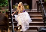 Sarah Jessica Parker sitzt auf den Stufen des berühmten New Yorker Apartments, in dem Carrie Bradshaw wohnt. | © gettyimages.de /  James Devaney 