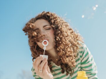 Junge Frau macht Seifenblasen | © GettyImages/Westen61