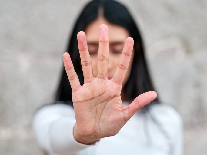 Frau hebt ihre Hand um zu sagen, es ist genug | © AdobeStock/Oscar