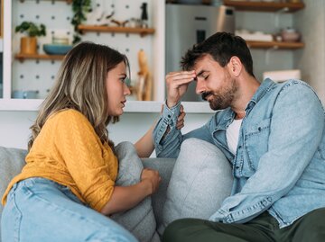 Paar diskutiert auf dem Sofa | © GettyImages/VioletaStoimenova