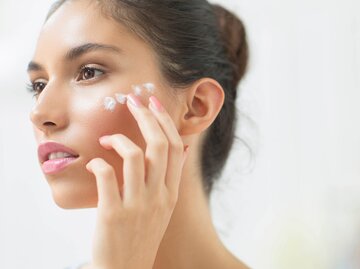 Schöne Frau trägt Sonnencreme im Gesicht auf | © gettyimages.de / Lumina Images