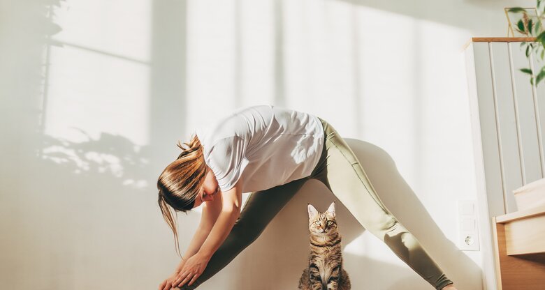Frau macht Yoga mit ihrer Katze | © GettyImages/	Kseniya Ovchinnikova