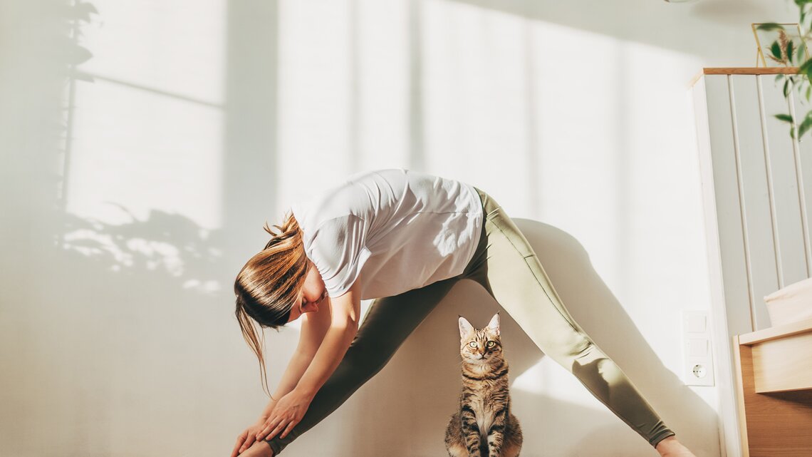 Frau macht Yoga mit ihrer Katze | © GettyImages/	Kseniya Ovchinnikova