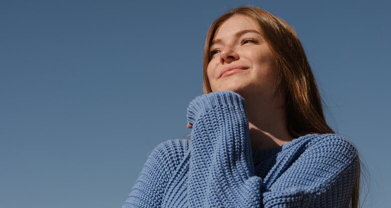 Frau lächelt, blauer Himmel | © 	GettyImages/Yulia Petrova