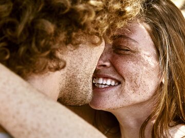 Sommersprossiges Paar lächelt sich glücklich an | © GettyImages/Westend61