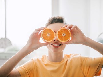 Frau hält Orangenhälften vor die Augen | © Getty Images/Carol Yepes