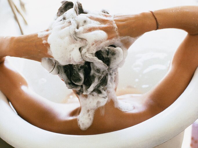 Frau shampooniert sich Haare in Badewanne | © Getty Images/John Dowland