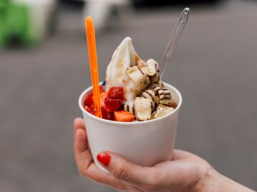 Frau hält Becher mit Frozen Joghurt in der Hand | © Getty Images/Maximilian Neumann / EyeEm