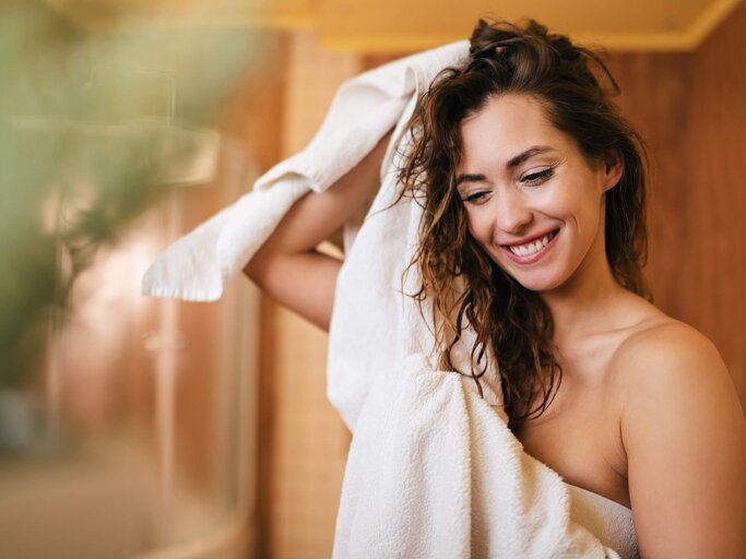 Frau mit handtuchtrockenen Haaren | © Getty Images/Drazen Zigic